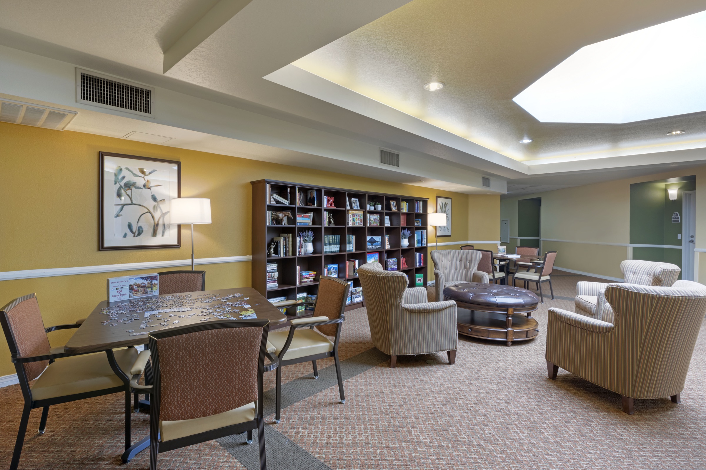 The library, with armchairs, shelves and a reading table