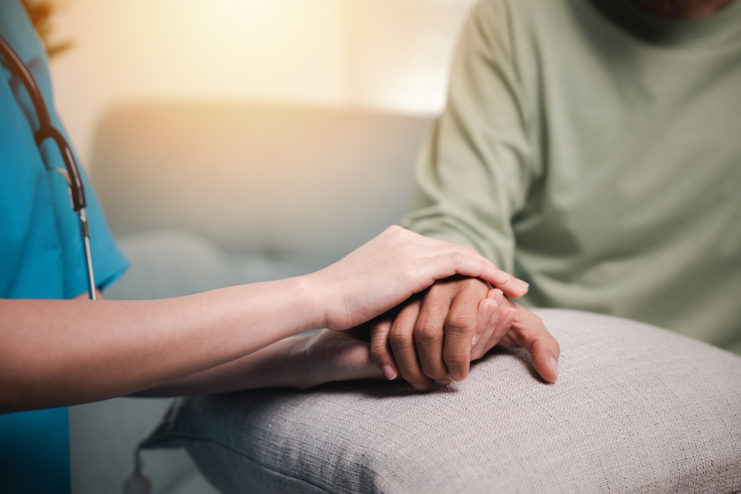 A carer holding a resident's hand, unhurried